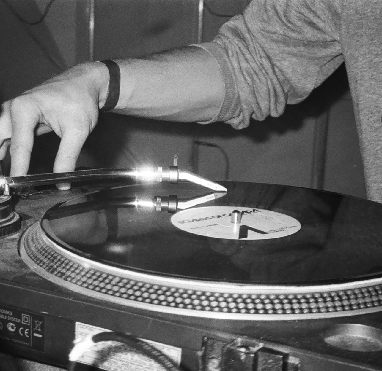 Closeup of a DJ's arm operating a turn table